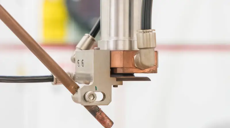 cnc laser cutting head cutting metal sheet in an industrial manufacturing setup