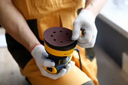 man working with an orbital sander