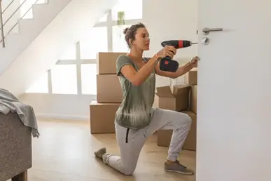 woman using bauer 20v drill to drill a hole in a door